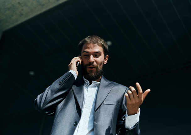 επιχειρηματίας σε ένα κοστούμι μιλάμε στο τηλέφωνο σε εξωτερικούς χώρους διευθυντής επιχειρήσεων - Φωτογραφία, εικόνα