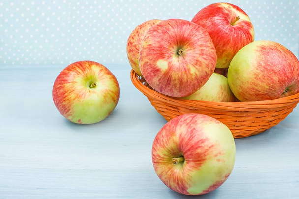Masanın üzerinde kırmızı bir fıçı olan elmalar. mavi arkaplan meyvesine karşı , - Fotoğraf, Görsel