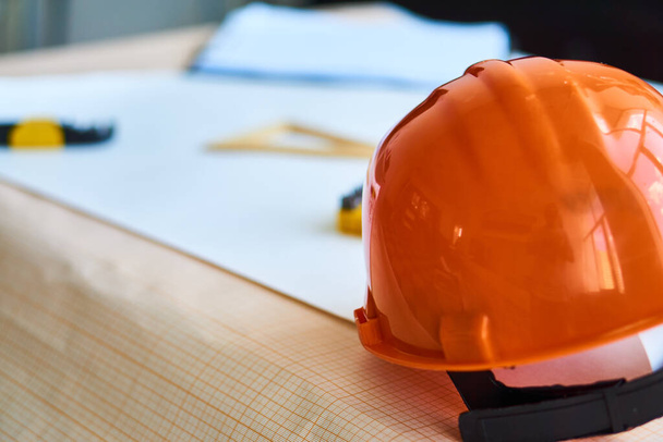 Narzędzia budowlane pomarańczowy twardy kapelusz inżynierii rysunki stół roboczy - Zdjęcie, obraz