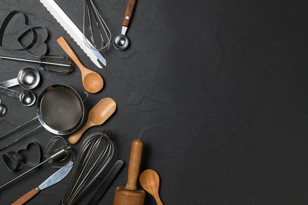 Kitchen utensils for pastries on black table and copy space, prepare for make cake and bakery concept - Photo, Image