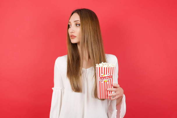 Close up zijprofiel foto van jonge mooie vrouw met popcorn  - Foto, afbeelding