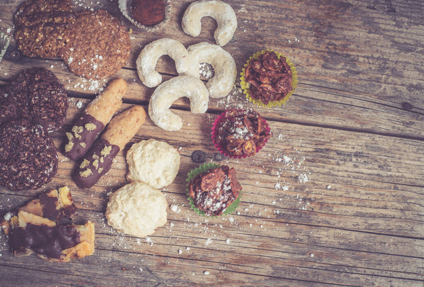 Closeup of variety of traditional European homemade Christmas cookies on rustic wooden desk - Foto, Imagem