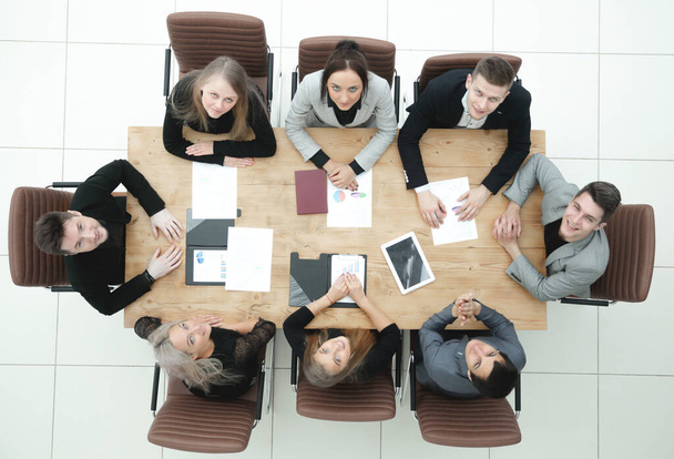 top view. young business team sitting at a table and looking at the camera - Photo, Image