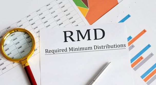 Papier mit erforderlichen Mindestverteilungen RMD auf einem Tisch mit Stift, Diagramm und Lupe - Foto, Bild