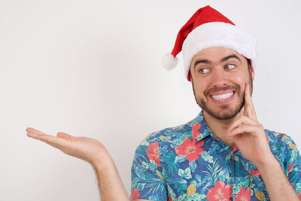 young man in Santa hat holding open palm   - Photo, Image