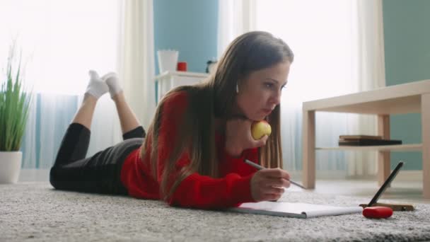Mujer está acostada en el suelo hablando con el mejor amigo y comiendo manzana - Imágenes, Vídeo