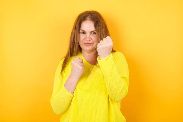 Beautiful mature woman  Ready to fight with fist defense gesture, angry and upset face, afraid of problem. - Photo, Image
