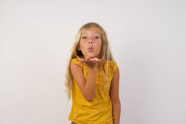 cute little girl blowing a kiss with hand on air being lovely. Love expression. - Photo, Image