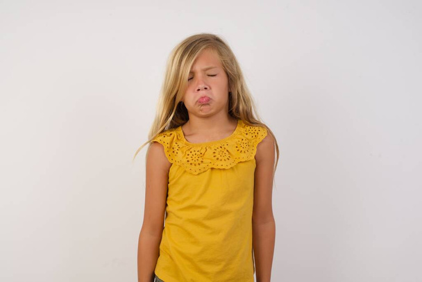 милая маленькая девочка кривит нижнюю губу и закрывает глаза в отчаянии, находясь в депрессии  - Фото, изображение