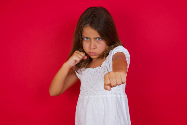 Cute little girl  punching air with fist and looking confidently at camera, male struggle, fighting spirit.  - Photo, Image