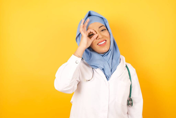 Gyönyörű női arab orvos sztetoszkóppal sárga stúdió háttér - Fotó, kép