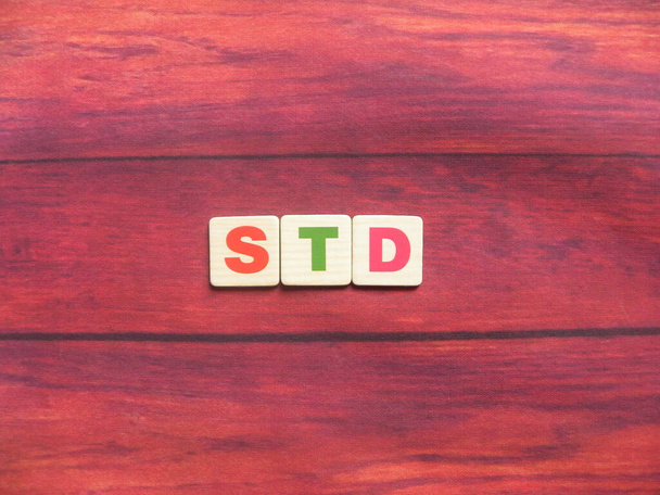 Afkorting STD (Sexually Transmitted Disease) op houtondergrond - Foto, afbeelding
