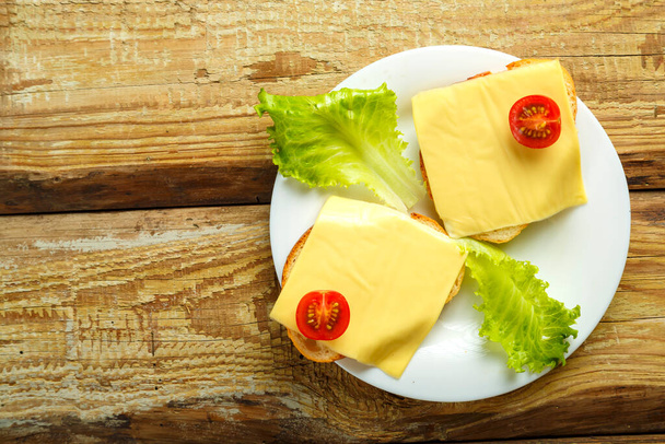 Sandwiches with cheese and cherry on a plate on a wooden table.copy place. - Foto, afbeelding