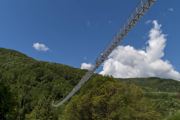 взвешенный мост Феррьере является пешеходной дорожкой, которая соединяет две стороны потока Лима между Mammiano Basso и Popiglio в муниципалитете Сан-Марчелло Piteglio. - Фото, изображение