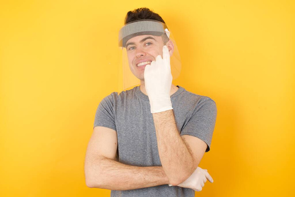 hombre en sombrero protector de plástico, gesto con la mano invitando a dar la bienvenida feliz y sonriente - Foto, Imagen