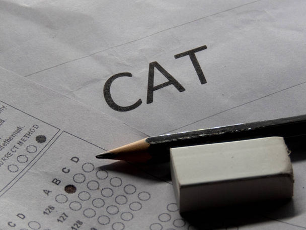 Έννοια της εξέτασης CAT ή κοινή δοκιμή εισαγωγής με γόμα μολυβιών και χαρτί. - Φωτογραφία, εικόνα