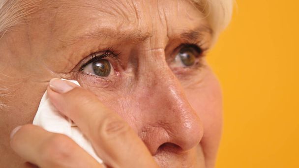 Primer plano de triste anciana vulnerable limpiando sus lágrimas - Foto, imagen