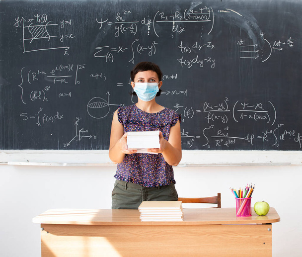 Teacher with face mask welcoming children back at school after lockdown. Back to school during COVID-19 pandemic. - Φωτογραφία, εικόνα