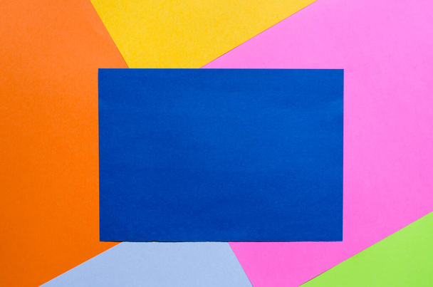 Sininen paperiarkki, jossa on paikka tekstille värikkäällä taustalla. - Valokuva, kuva