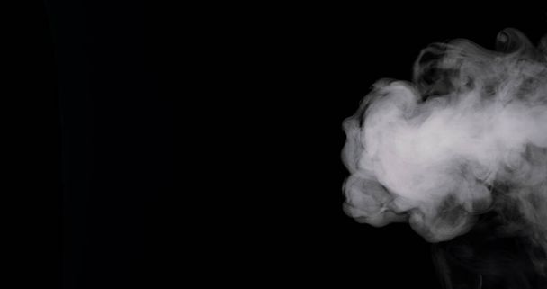 sűrű füst ömlik a fekete háttér felé. - Fotó, kép