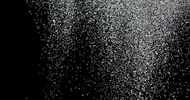 Cloud of shiny snowflakes floating in the air. The shot was taken while the snowflakes were on an isolated black background. - Photo, Image