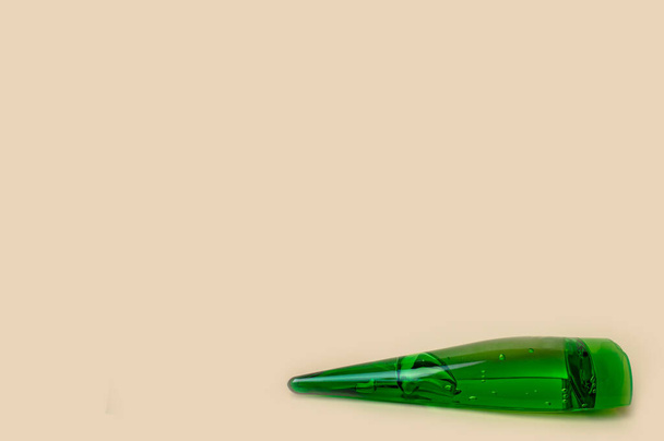 zielona butelka z kosmetycznym żelem aloesowym na żółtym tle zbliżenie - Zdjęcie, obraz