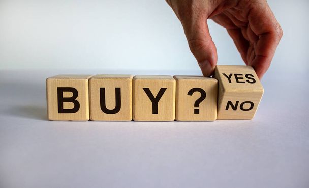 Time to buy. Hand turns a cube and changes the word 'no' to 'yes'. Beautiful white background. Business concept. Copy space. - 写真・画像