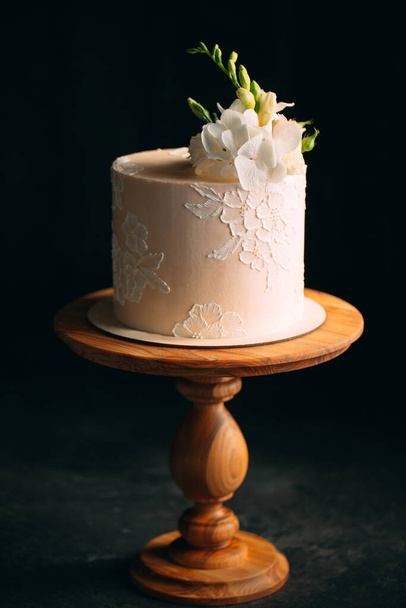 Cake is decorated with flowers on a dark background. - Fotó, kép
