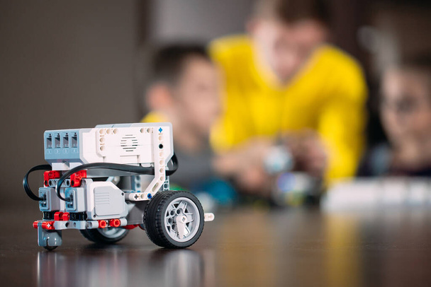 Kids creating robots with teacher. Early development, diy, innovation, modern technology concept. - Foto, imagen