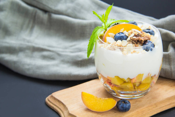 Healthy blueberry, peach and walnut parfait in a glass - Photo, Image