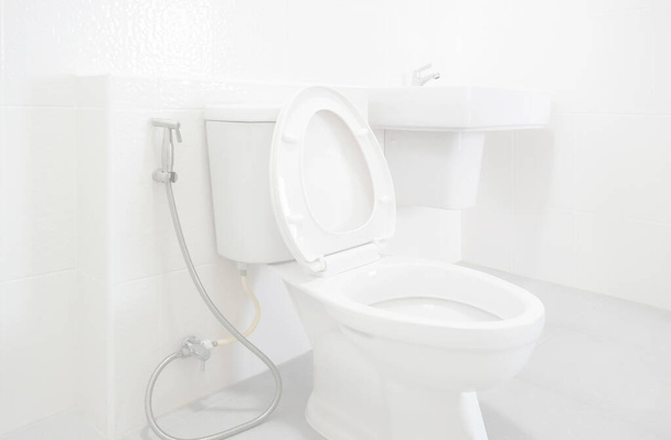 Білий унітаз в чистому і новому білому керамічному розкішному туалеті, здоровий гігієнічний концепт інтер'єру вбиральні
 - Фото, зображення
