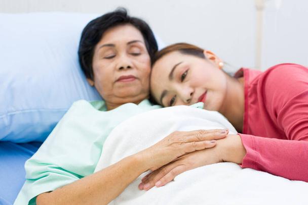 The lovely daughter comes to visit the sick mother while her mom is recuperating at the hospital. Elderly health care concept. - Photo, Image
