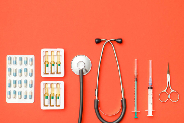 Top view of doctor's table with stethoscope and other equipment. Colored background. Top view. Flat lay - Photo, Image