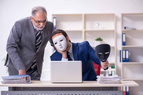 Old boss and young male employee wearing masks - Zdjęcie, obraz