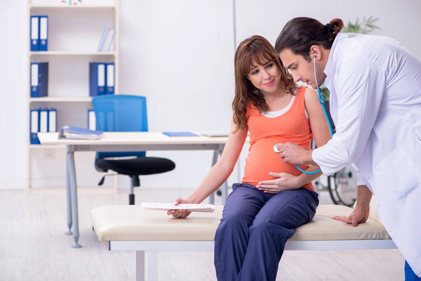 Zwangere vrouw op bezoek bij mannelijke gynaecoloog - Foto, afbeelding