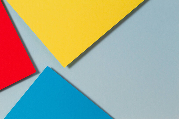 Soyut renk kağıtları geometri düz kompozisyon arkaplan mavi, sarı ve kırmızı renk tonlarıyla - Fotoğraf, Görsel