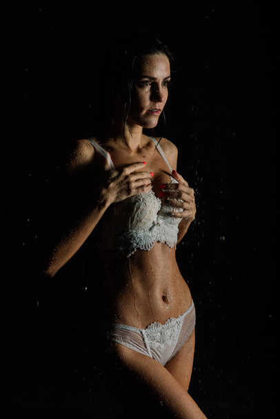Young woman with beautiful sportive body in perfect shape with water drops in white lingerie in aquastudio - Photo, Image