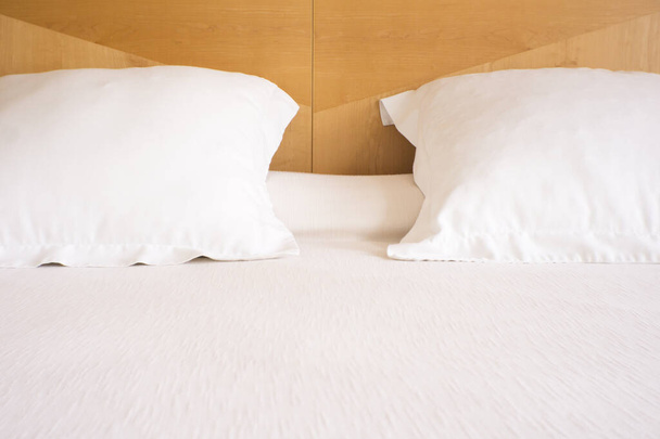 Μαξιλάρια με λευκά καλύμματα σε πολυτελές ξενοδοχείο king size κρεβάτι. Όχι άνθρωποι. - Φωτογραφία, εικόνα