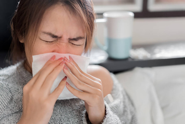 Sick asian woman have hight fever flu and sneezing into tissue on bed in bedroom, Medical and health concept, Selective focus. - Фото, изображение