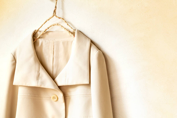 beige or white jacket hanging on clothes hanger on white background.close up. - Foto, Imagem