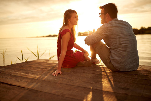 Young lovers and a beautiful sunset on the lake - Photo, Image