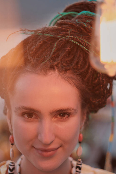 Portret van jonge vrouw met stijlvolle kapsel op zoek naar camera op partij - Foto, afbeelding