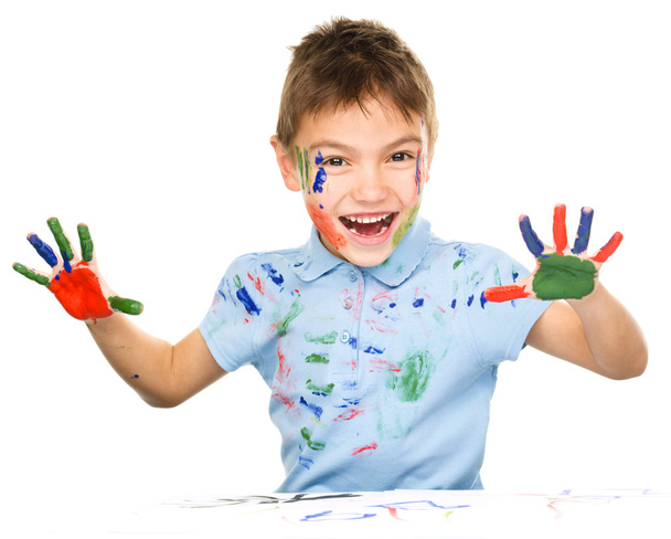 Portrait of a cute boy playing with paints - 写真・画像