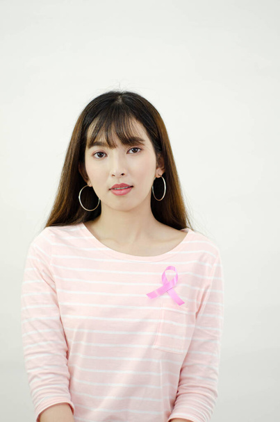 Pink ribbon affixed on an Asian woman's shirt.Do not focus on objects.World Breast Cancer Day Concept. - Photo, Image