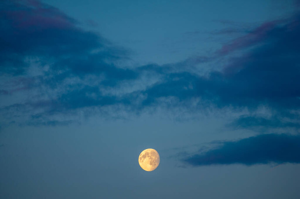 夜の写真。雲のある空の月は太陽によって彩色されています。月の光月の輝き輝き - 写真・画像