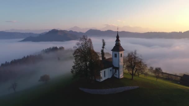 日没時のスロベニアの聖トーマス教会の空中ビュー - 映像、動画