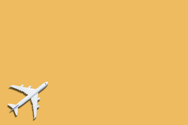 Avión de juguete miniatura sobre fondo amarillo. Viaje en avión. - Foto, imagen