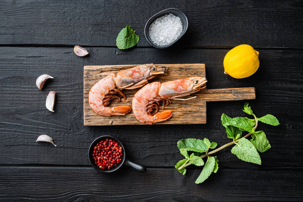 Seafood scampi on wooden board on black wooden background, flat lay, food photo. - Photo, Image