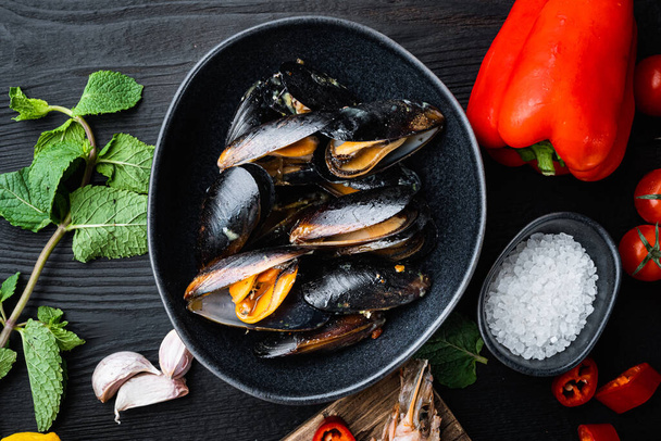 Traditional corsican mussel in bowl on black wooden background, flat lay, food photo. - Photo, Image