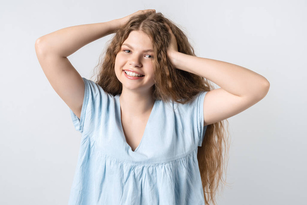 Portrait of attractive carefree european girl, tilting head up and shaking curly hair. Living life to fullest. Having fun and being amused. - Photo, Image